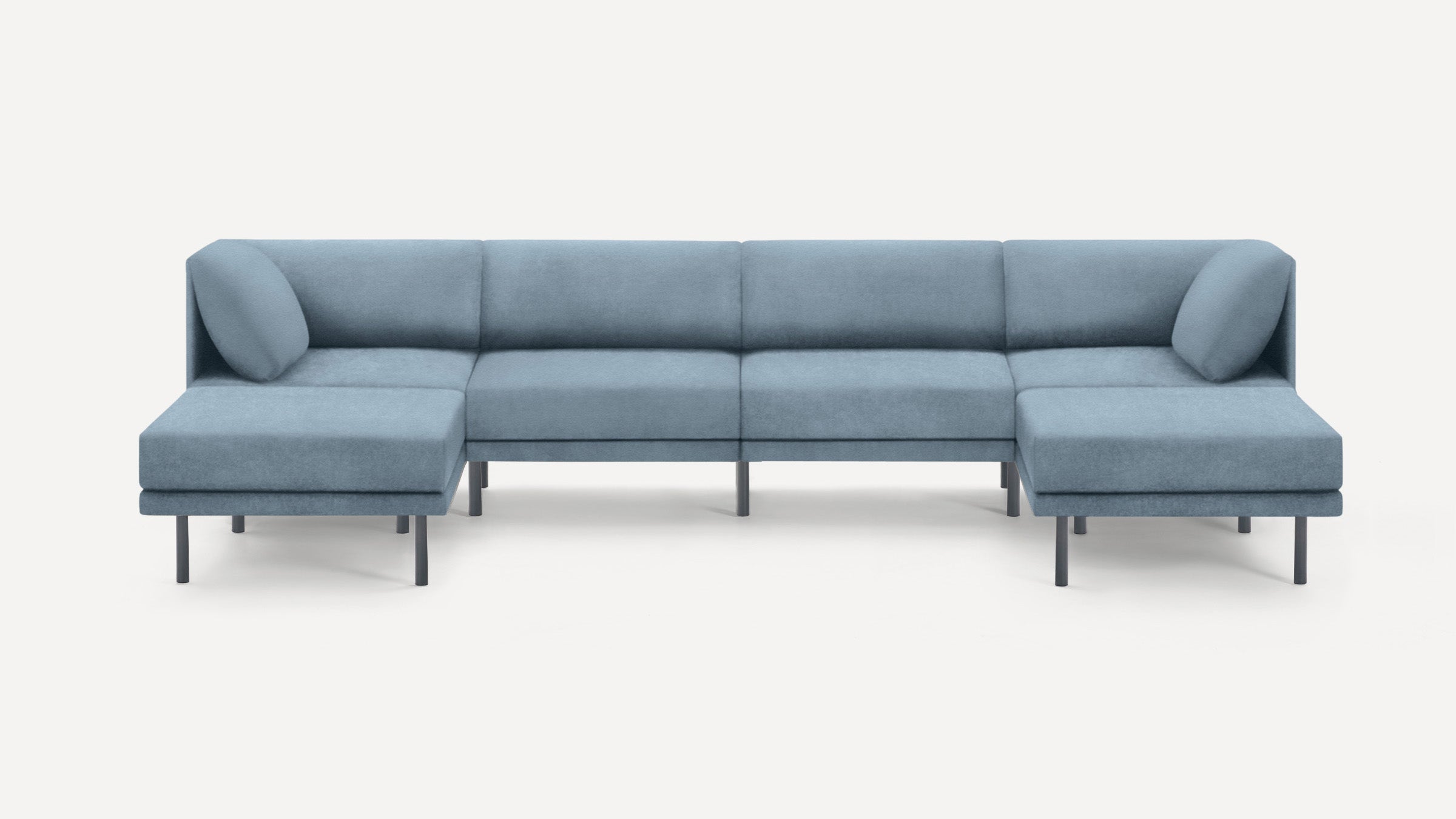 Modern light blue sectional sofa with low backrests, two angled cushions, and thin black legs on a white background.