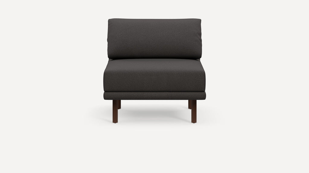 Modern dark gray armless lounge chair with cushioned seat and backrest, supported by four short wooden legs.