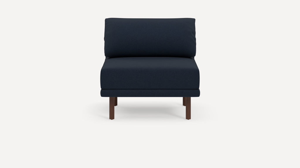 Modern navy blue armless chair with thick cushioned seat and backrest, supported by four dark wooden legs.