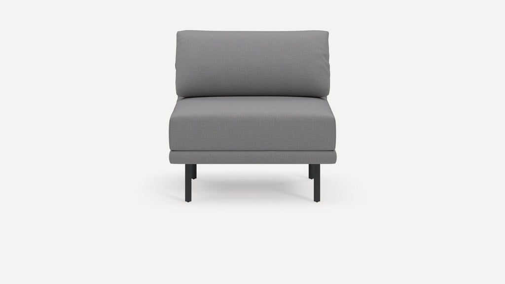 Modern armless gray upholstered chair with cushioned backrest and seat, supported by slender black metal legs.