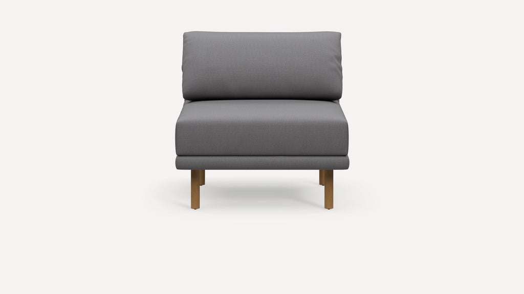 Front view of a modern armless gray upholstered chair with wooden legs on a white background.