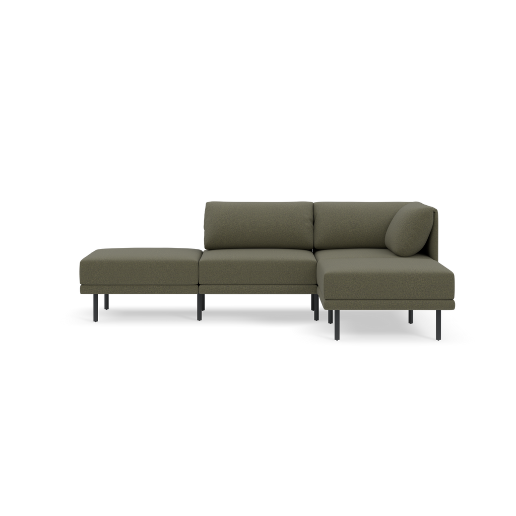 Modern Moss green sectional sofa with metal legs, featuring two seat cushions, a chaise lounge, and a round bolster pillow on a black background.