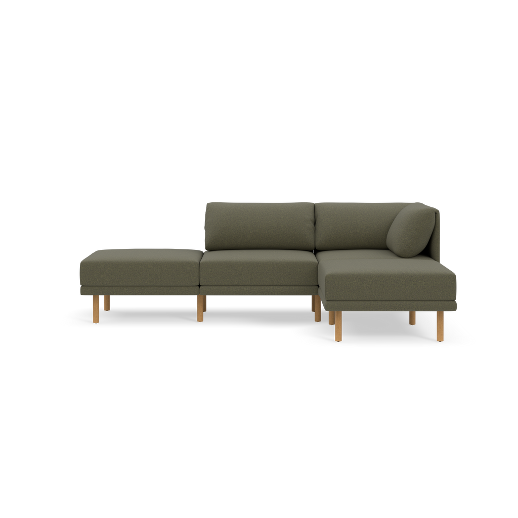Modern Moss green fabric sectional sofa with wooden legs, comprising two-seat and chaise lounge sections, shown against a black background.