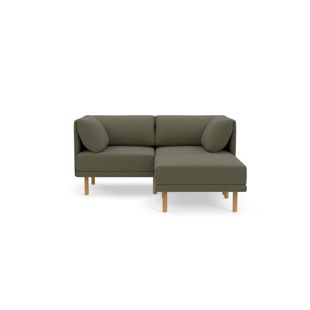 Modern Moss green fabric L-shaped sectional sofa with wooden legs and matching cylindrical cushions on each side.