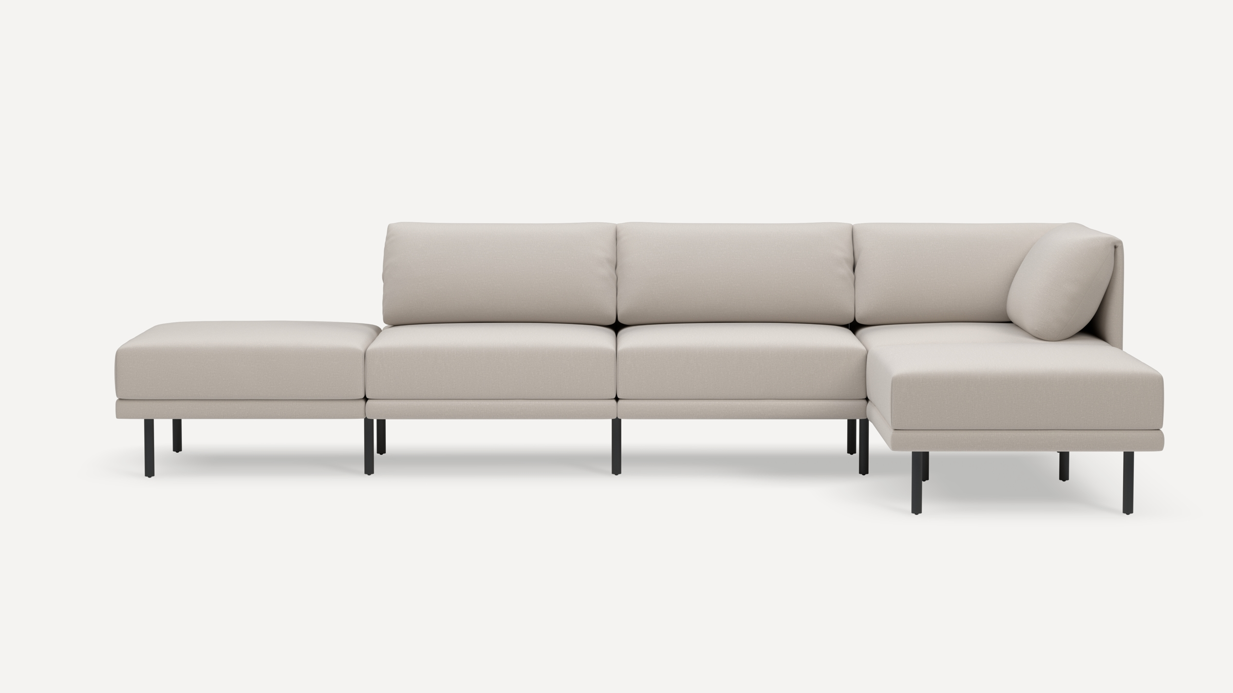 Modern beige sectional sofa with black metal legs, featuring three seat cushions, an ottoman, and an extended chaise lounge with backrest cushions.
