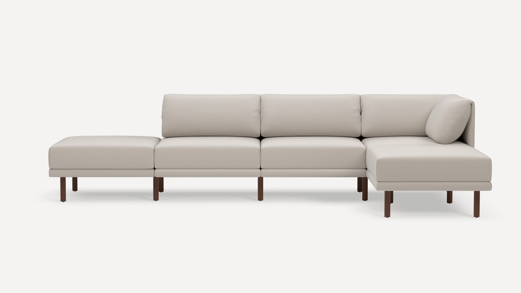 Beige modern sectional sofa with clean lines, plush cushions, wooden legs, and an attached chaise lounge for extra seating comfort.
