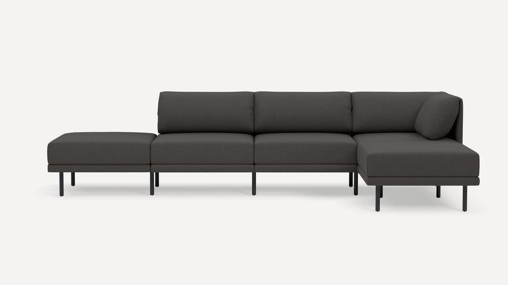 Modern dark gray sectional sofa with a left-side ottoman and right-side chaise, supported by slim black metal legs.