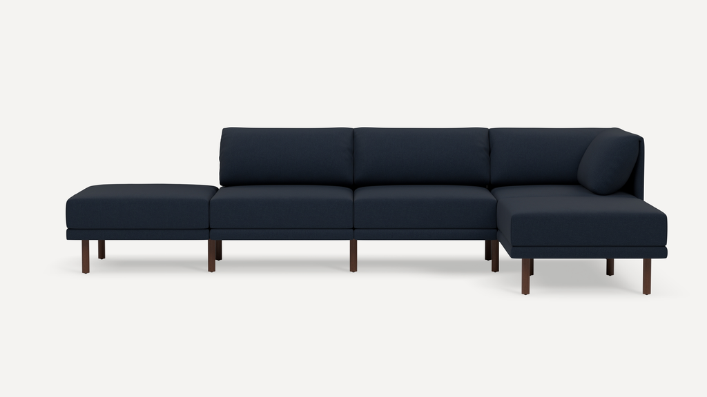 Modern navy blue sectional sofa with chaise lounge, featuring clean lines and wooden legs on a white background.