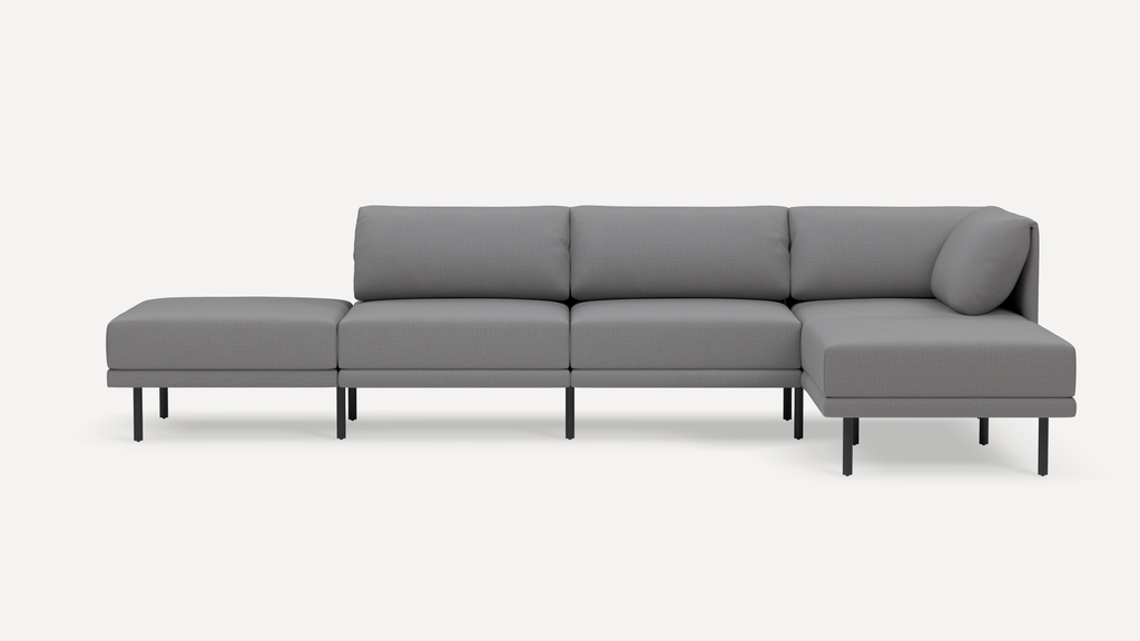 Modern gray sectional sofa with a chaise lounge on the right and an ottoman on the left, supported by black metal legs.