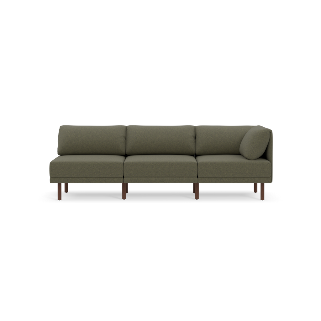 Modern Moss green three-seat sofa with wooden legs and a round bolster pillow on one end, set against a black background.