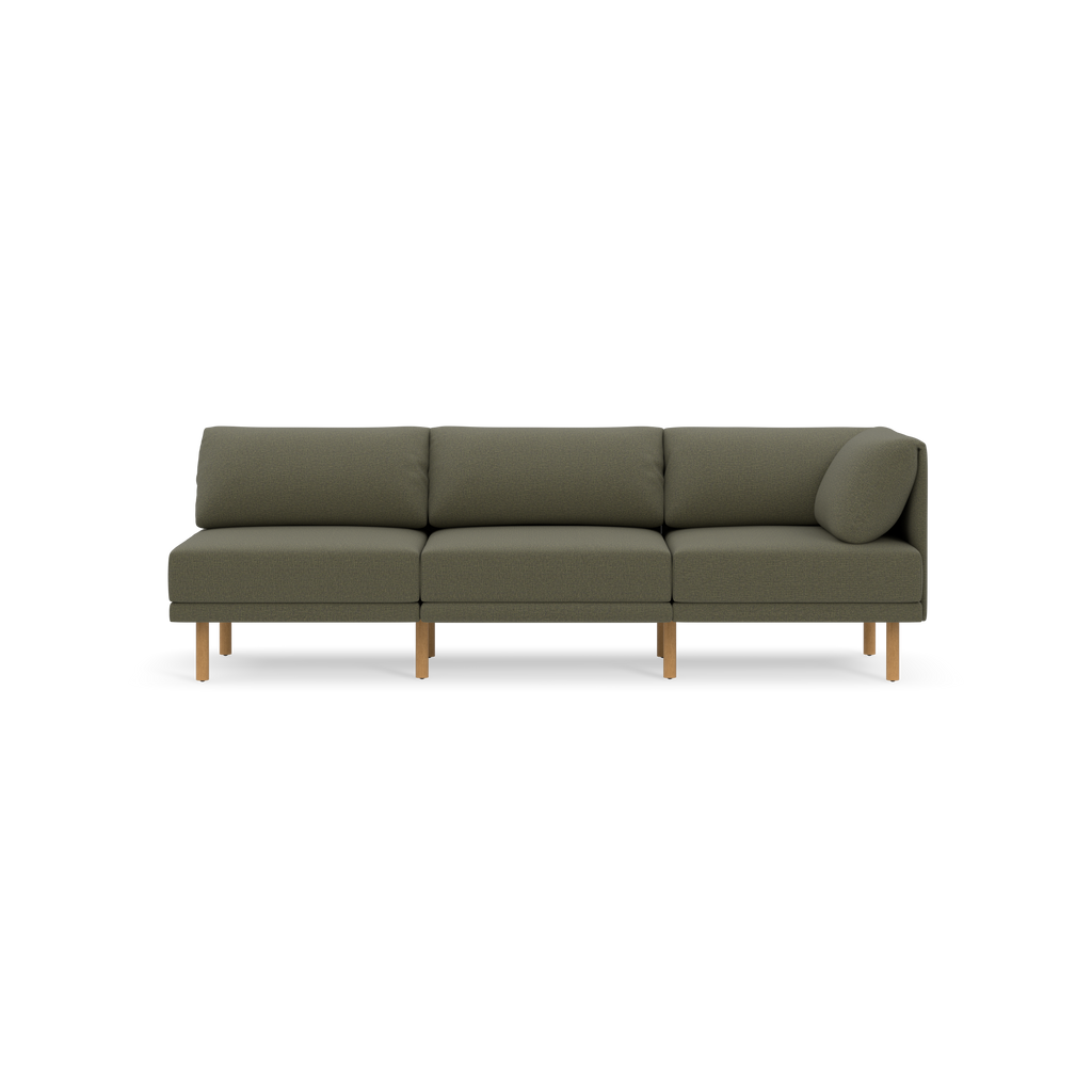 Modern Moss green three-seat sofa with wooden legs and cushion armrest on the right side, set against black background.