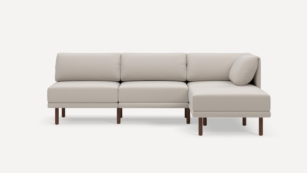 Modern beige sectional sofa with wooden legs, clean lines, and plush cushions, featuring a right chaise lounge.