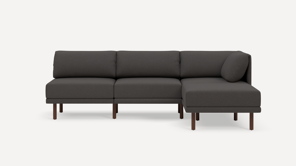 Modern dark gray fabric sectional sofa with wooden legs, three seat cushions, and a right chaise lounge.