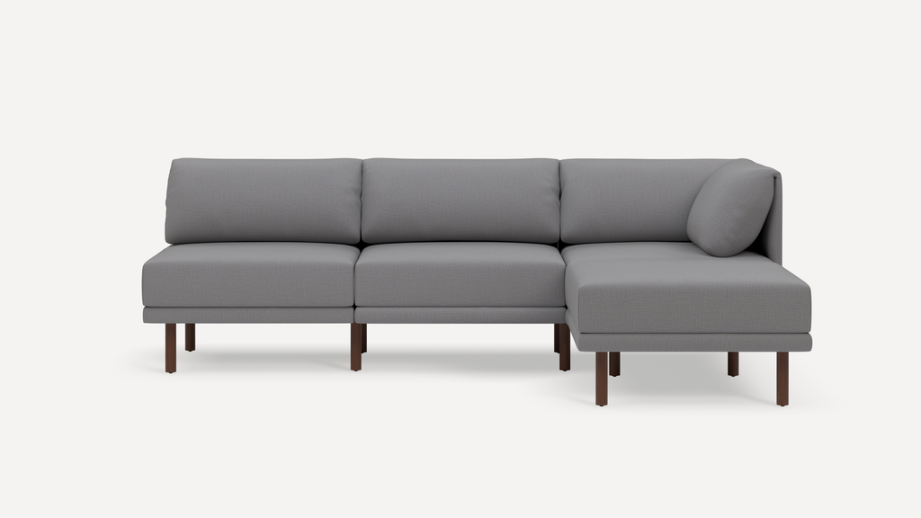 Modern gray three-seater sectional sofa with wooden legs and a right-side chaise lounge on a white background.