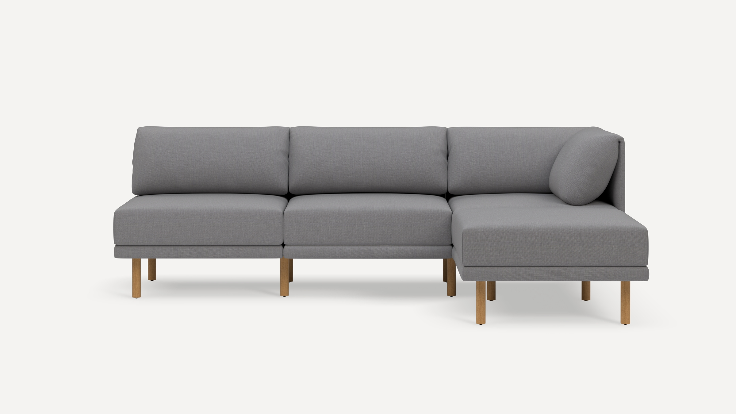 Modern gray fabric sectional sofa with wooden legs, featuring three seats and a chaise lounge on the right side.