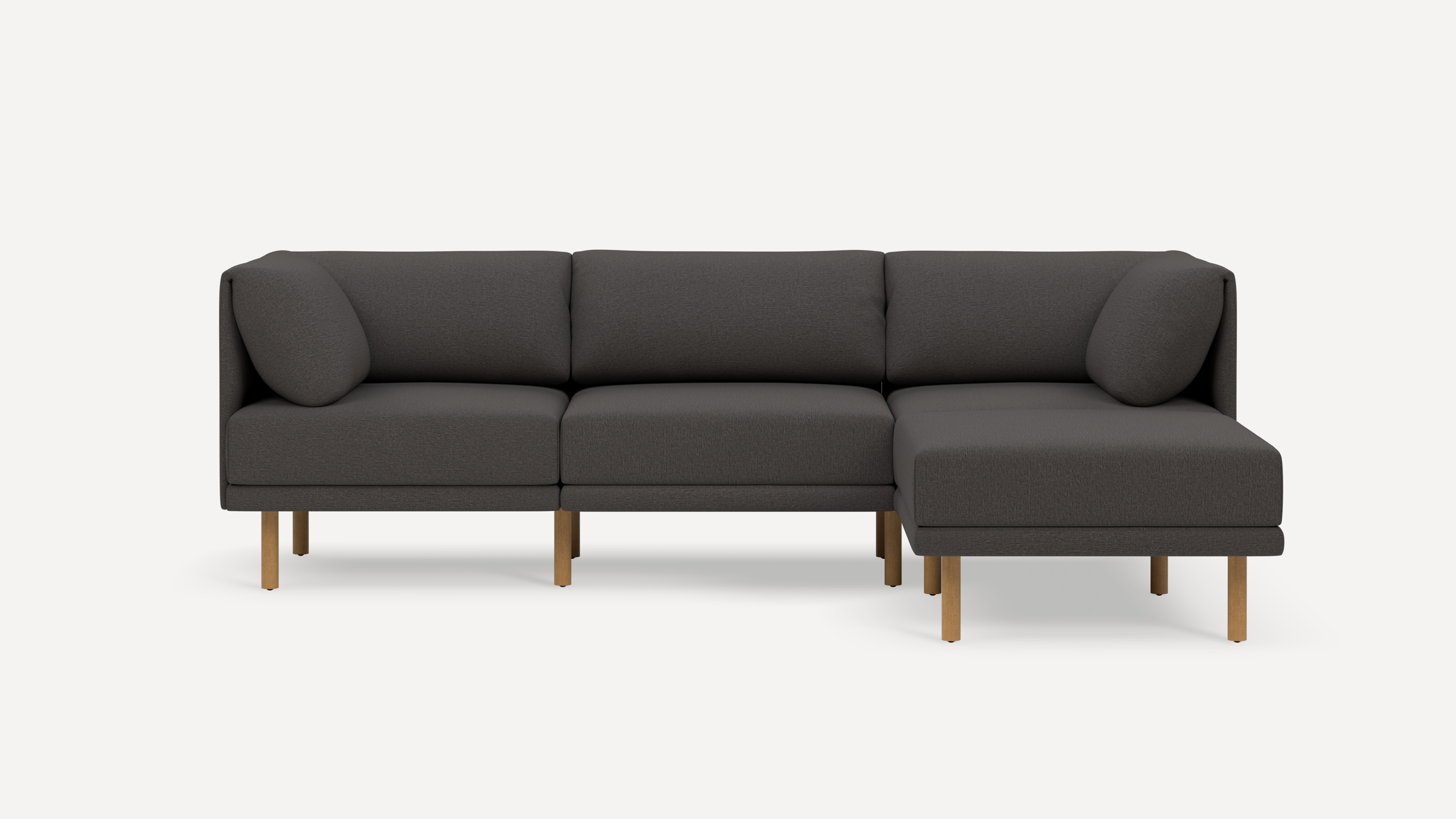 Modern dark gray sectional sofa with wooden legs, featuring three seats and a chaise lounge on the right side.