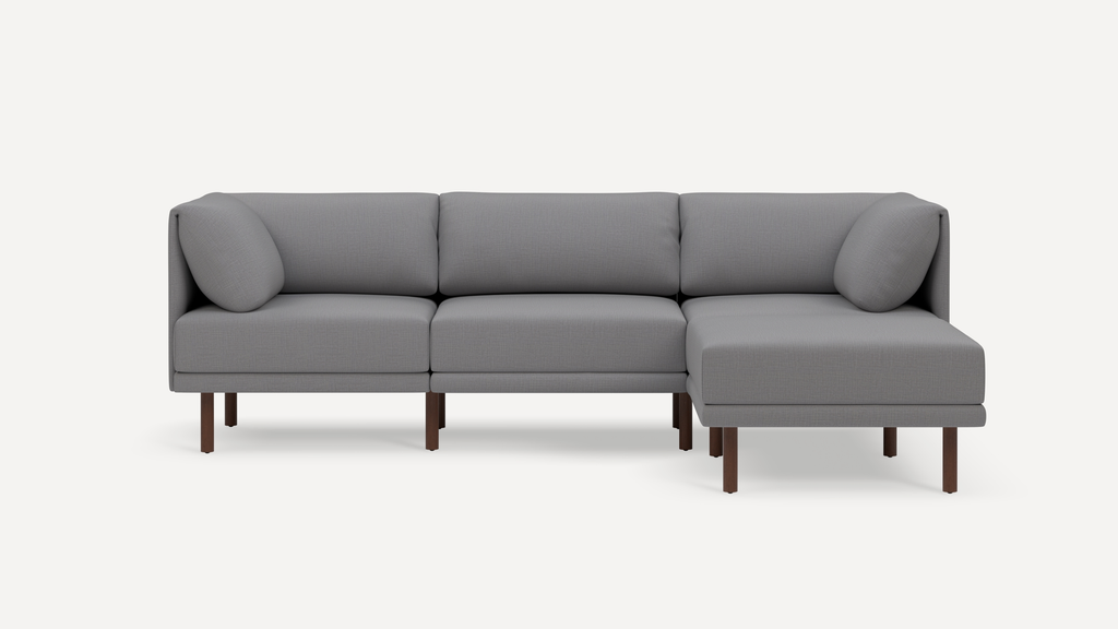 Modern gray sectional sofa with wooden legs, featuring clean lines and plush cushions, designed for comfortable seating.