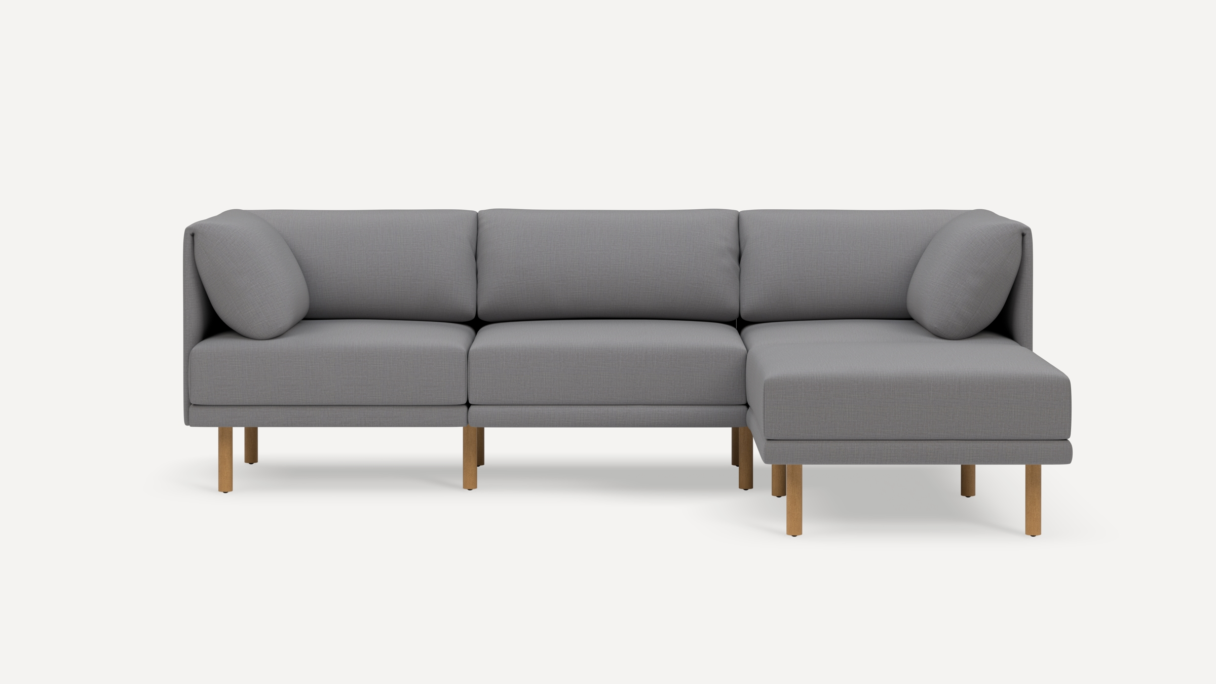 Modern gray fabric sectional sofa with wooden legs, cushioned seats, and backrest pillows, featuring a right-side chaise lounge.