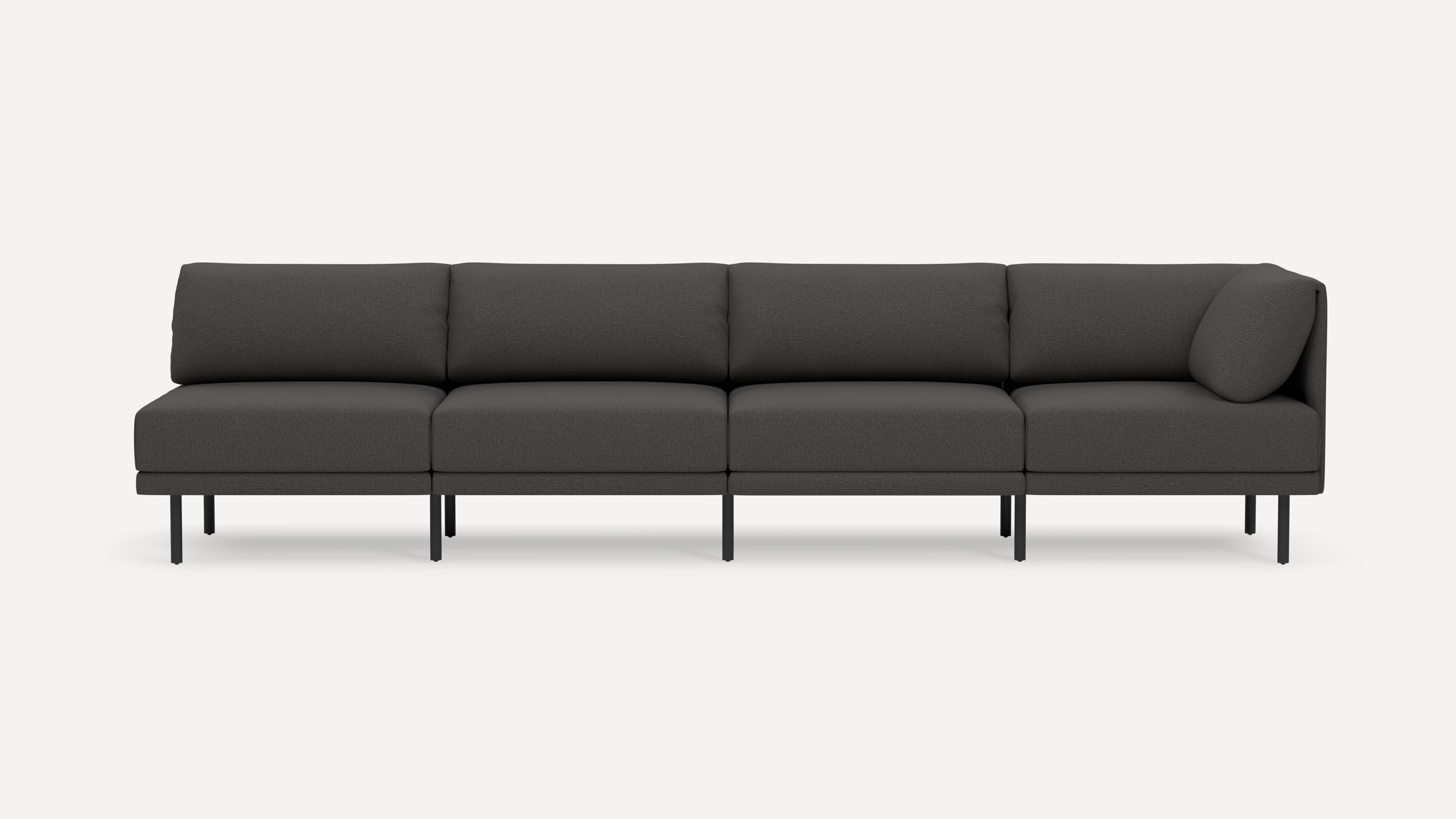 Modern dark gray four-seater sectional sofa with slim black metal legs and plush cushioned back and seat, isolated on white background.