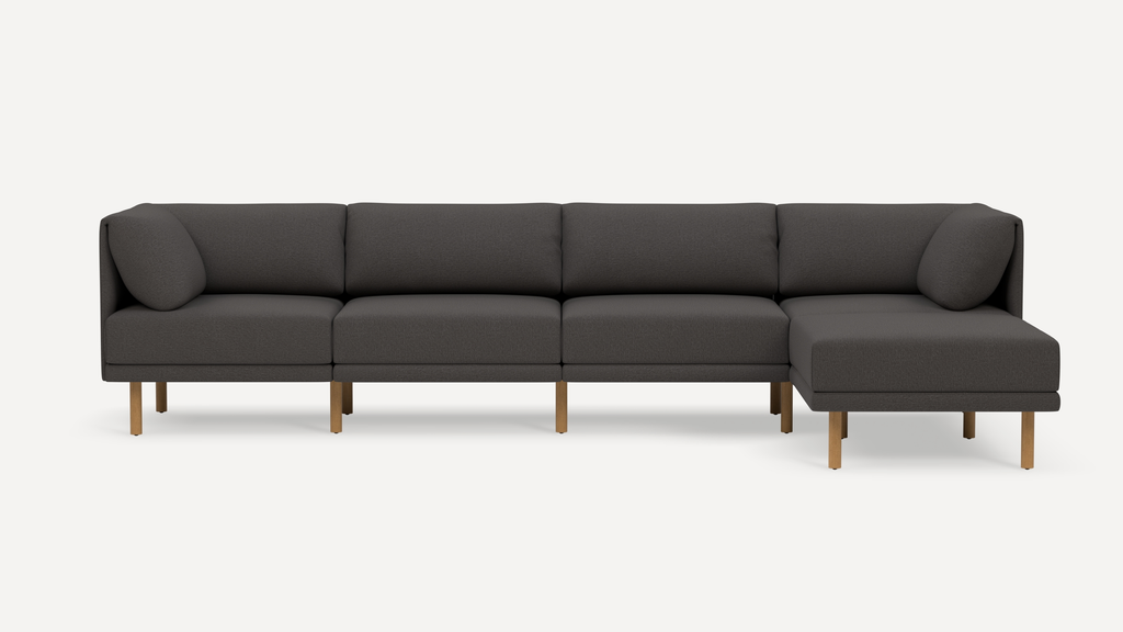 Modern dark gray sectional sofa with wooden legs, featuring a right-side chaise and plush cushioned backrests.