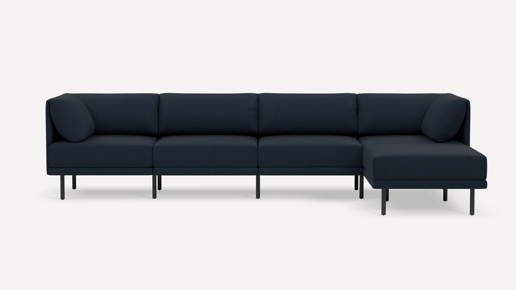 Modern dark navy-blue sectional sofa with clean lines, metal legs, and two corner cushions, designed for spacious seating.