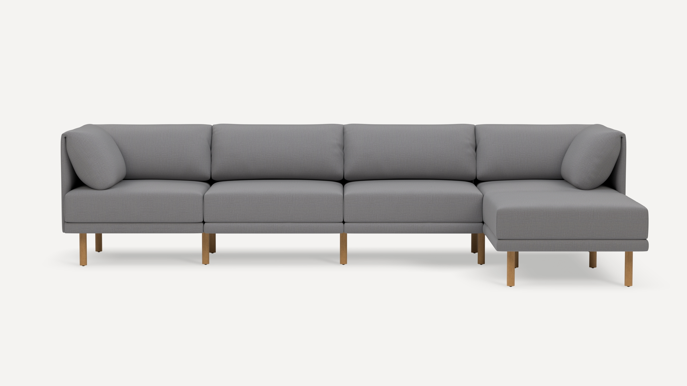 Modern L-shaped sectional sofa with light gray fabric upholstery and wooden legs, featuring plush back cushions and rounded armrests.