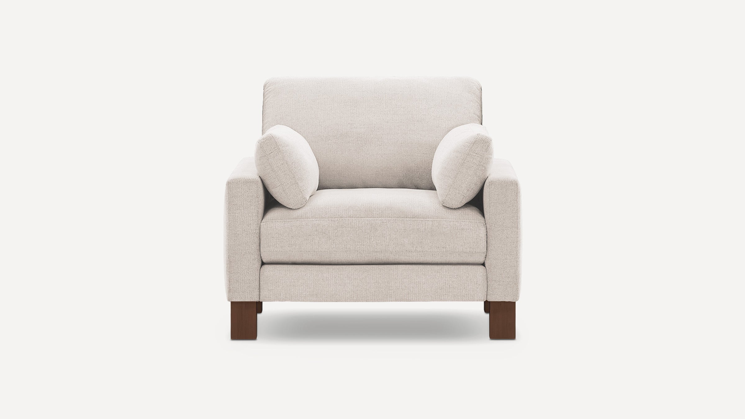 Beige fabric armchair with wooden legs, square arms, and two matching lumbar pillows, shown against white background.