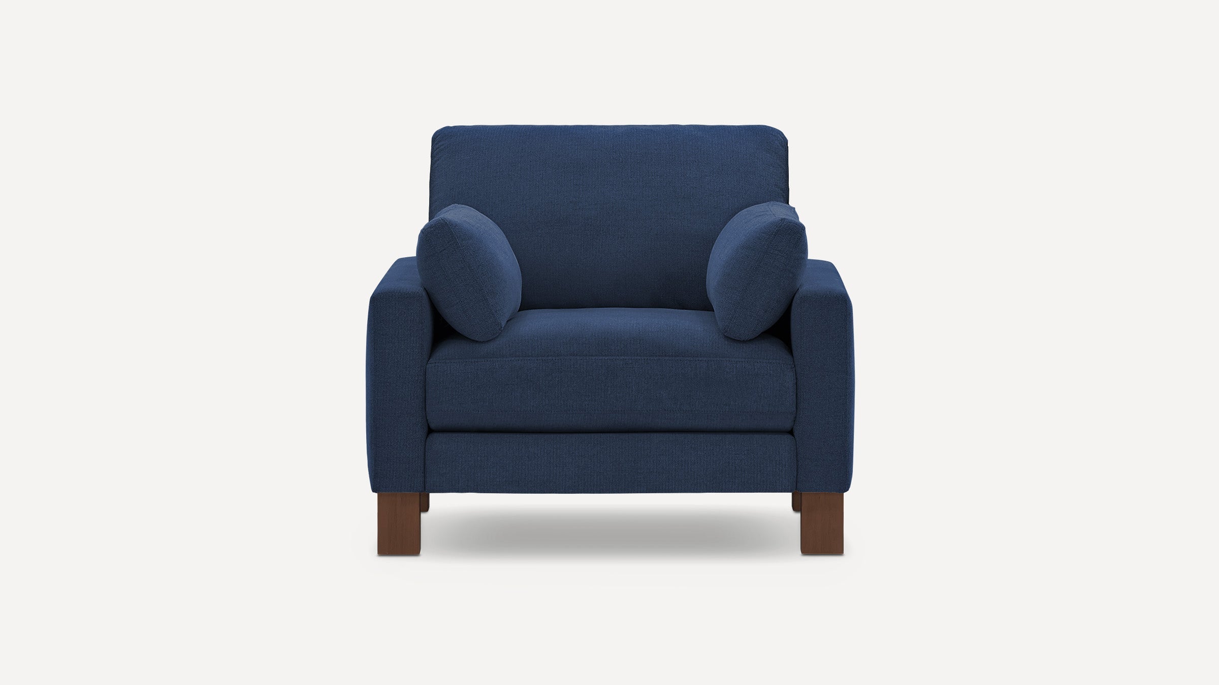 Modern single-seater armchair in navy blue fabric with thick cushions and wooden block legs, shown on white background.