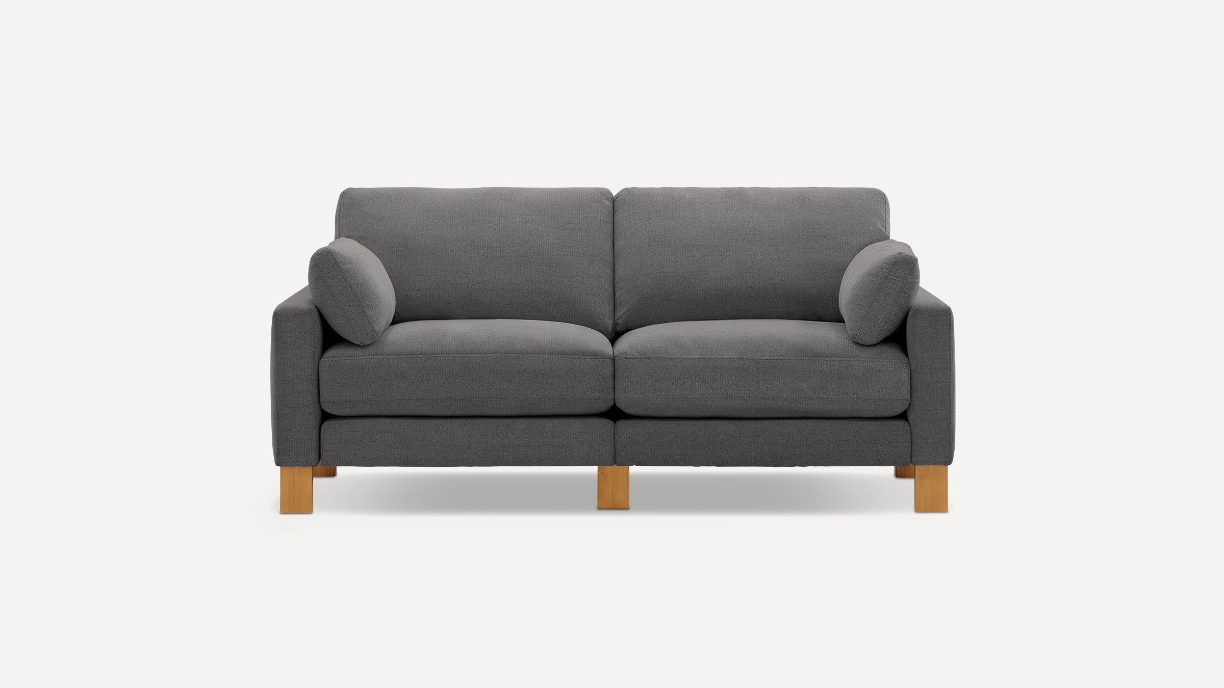 Modern dark gray fabric loveseat sofa with two side cushions and wooden block legs on white background.
