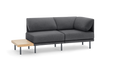 modern gray fabric sectional sofa with black metal legs and a wooden side table on a black background