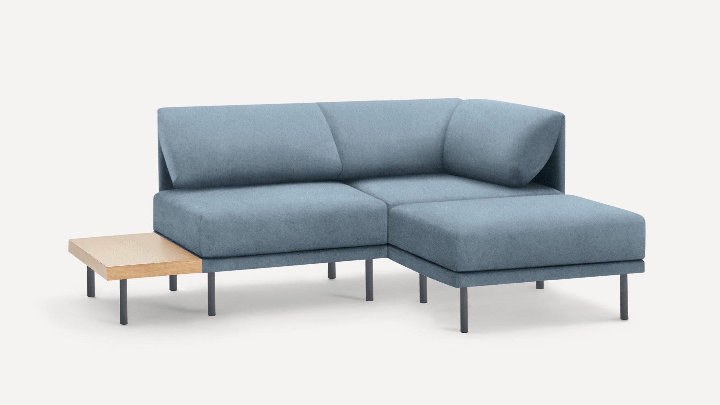modern blue sectional sofa with chaise lounge and wooden side table on white background