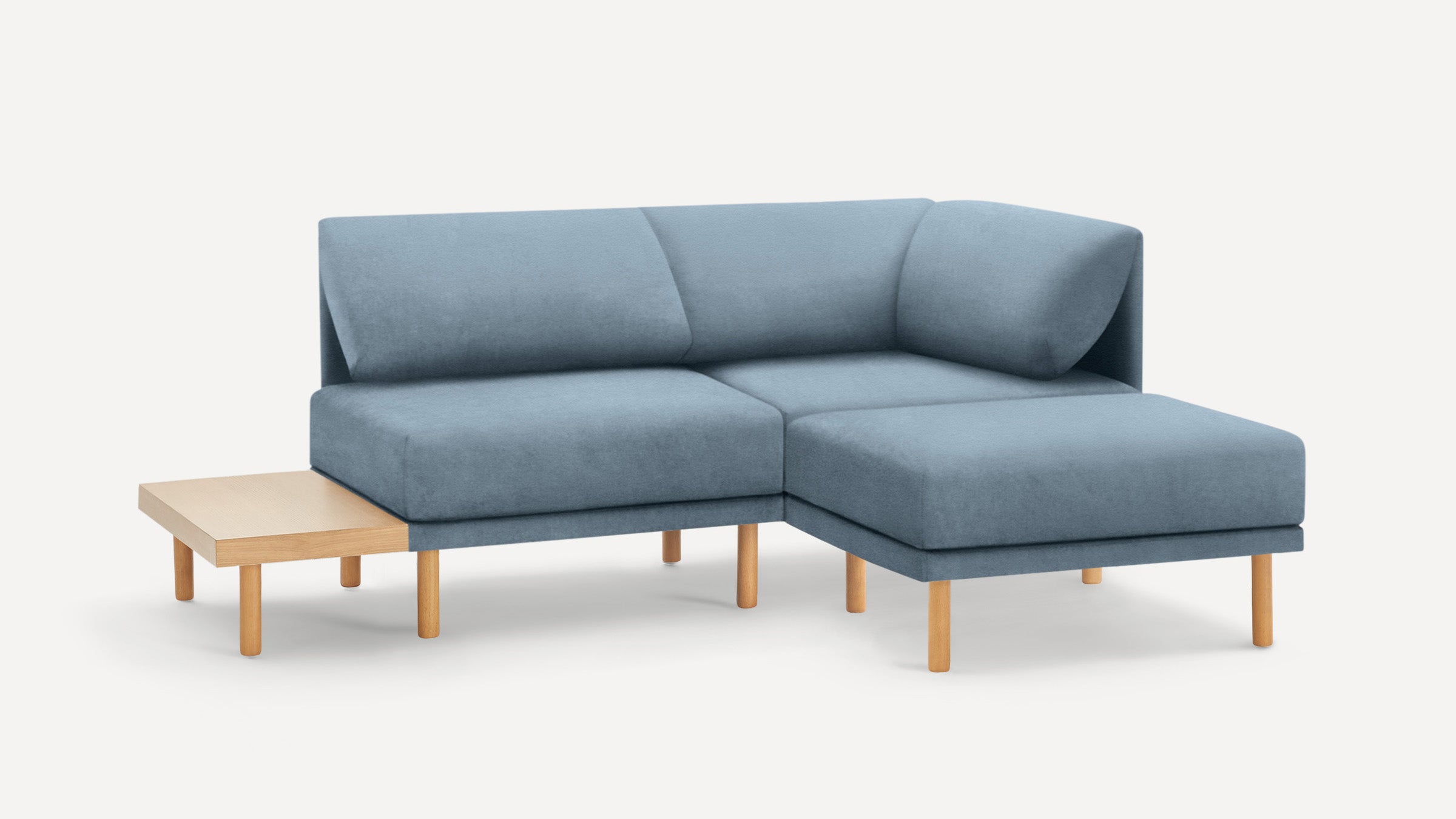 modern light blue sectional sofa with wooden legs and matching ottoman, featuring a clean, minimal design