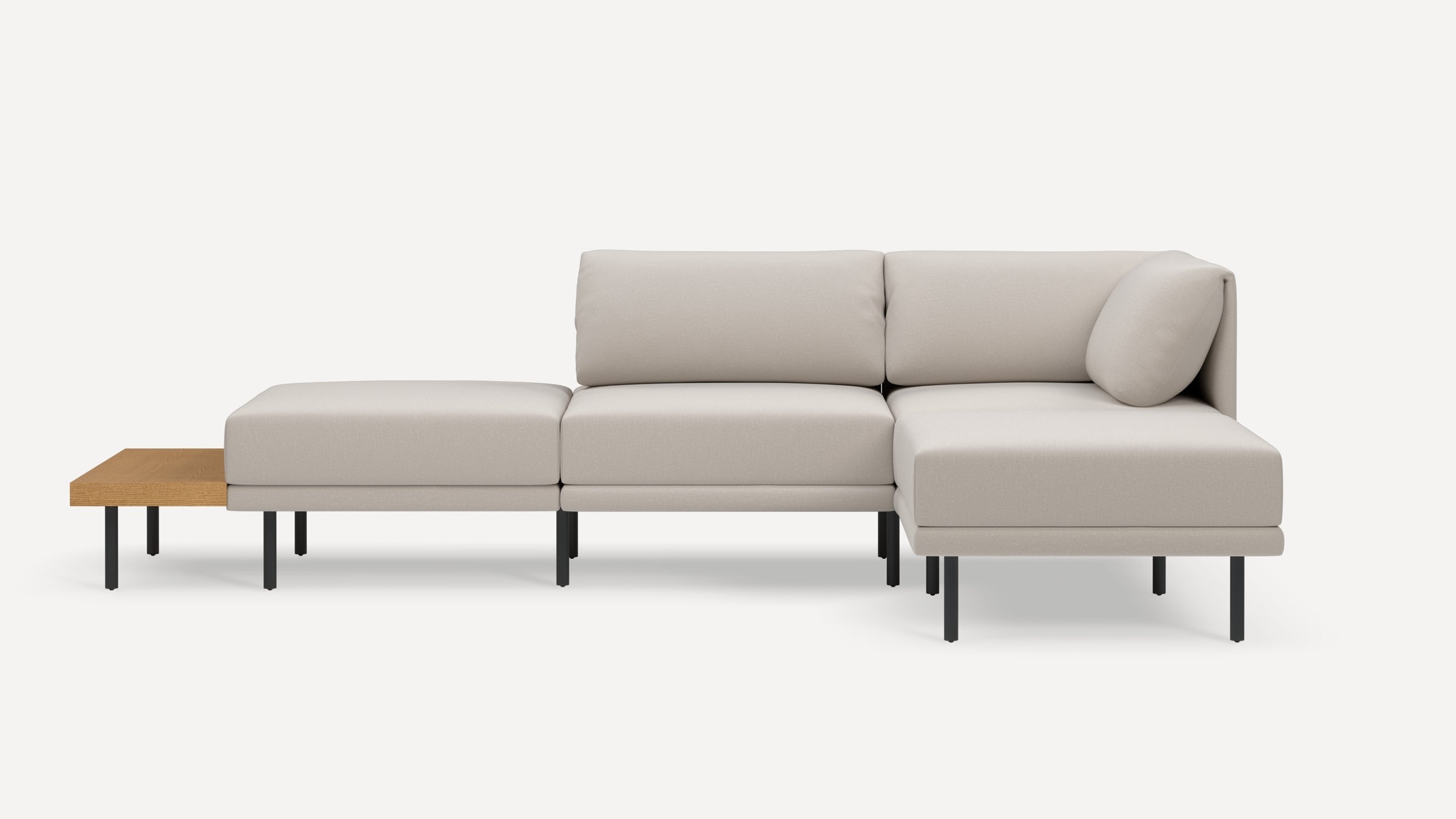 Modern sectional sofa in light beige fabric with black metal legs and a wooden side table attachment.