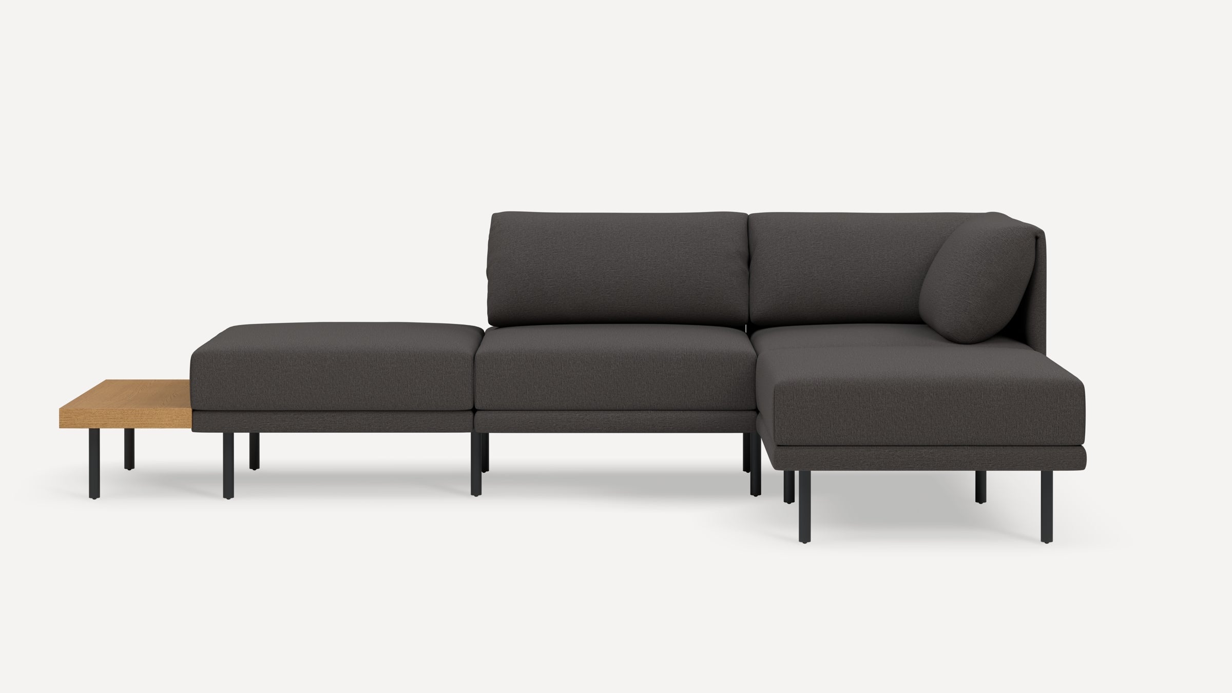 Modern dark gray sectional sofa with metal legs and attached light wood side table on left side, set against a plain white background.
