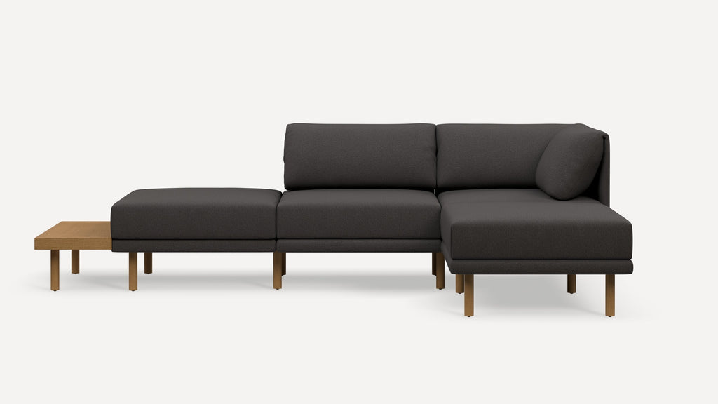 Modern dark gray sectional sofa with wooden legs and attached side table, featuring clean lines and minimalist design.