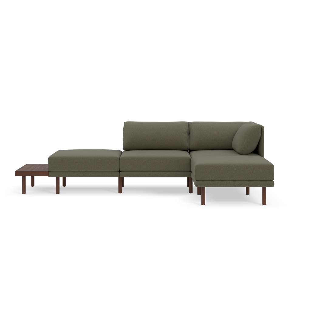 Modern modular Moss green fabric sectional sofa with wooden legs and attached low wooden side table.