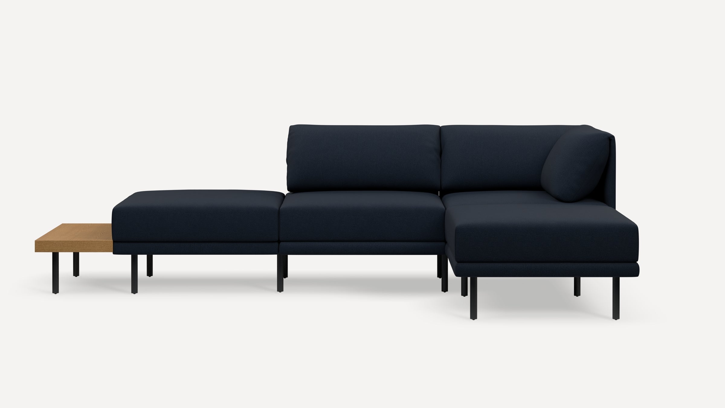Modern navy blue sectional sofa with slim black legs, featuring a wooden side table extension on the left side.