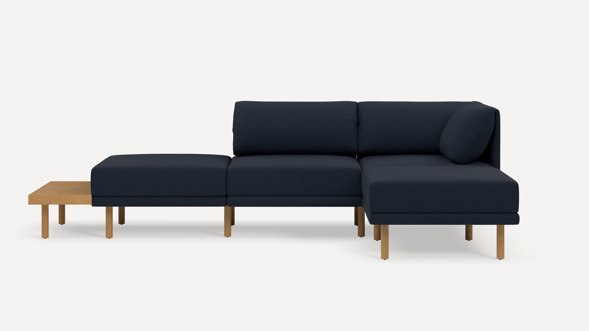 Modern navy blue sectional sofa with wooden legs and an attached wooden side table on the left side.