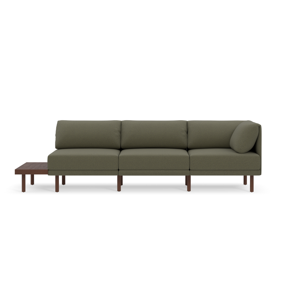 Modern Moss green three-seater sofa with wooden legs and an attached wooden side table on the left side, isolated on black background.
