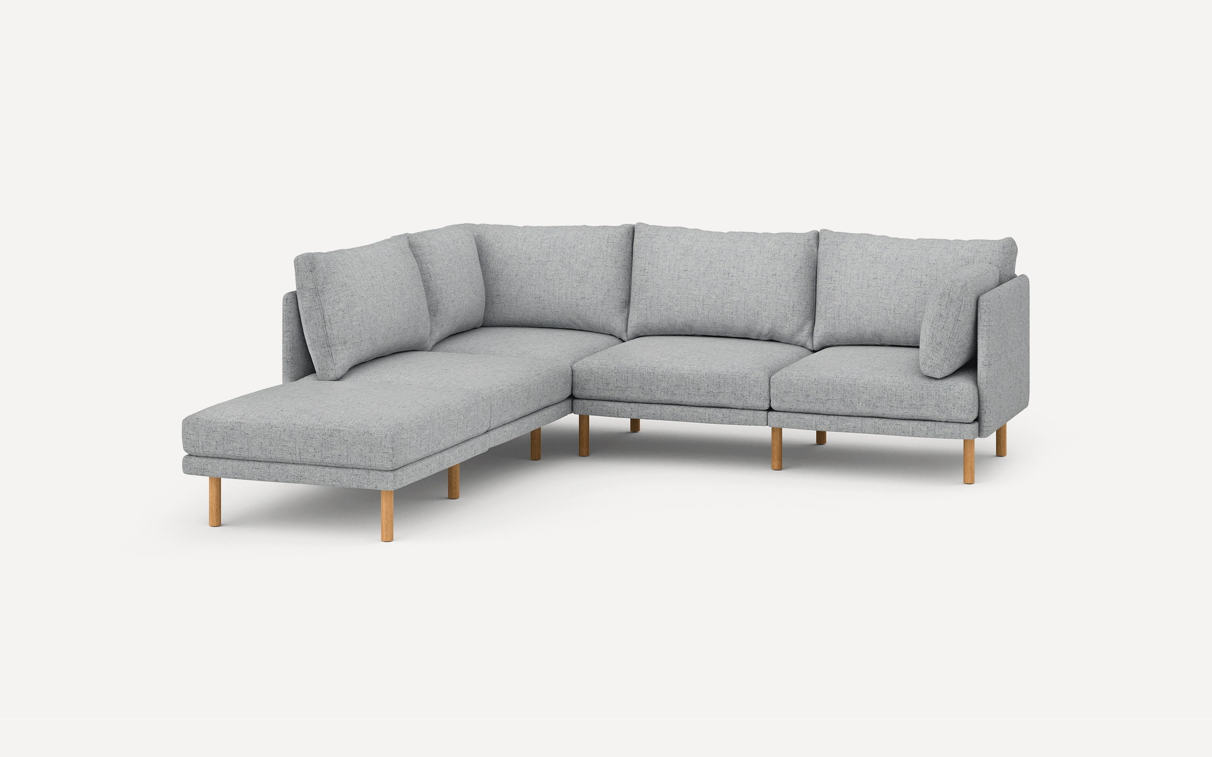 Light gray L-shaped sectional sofa with wooden legs and plush back cushions, set against a plain white background.