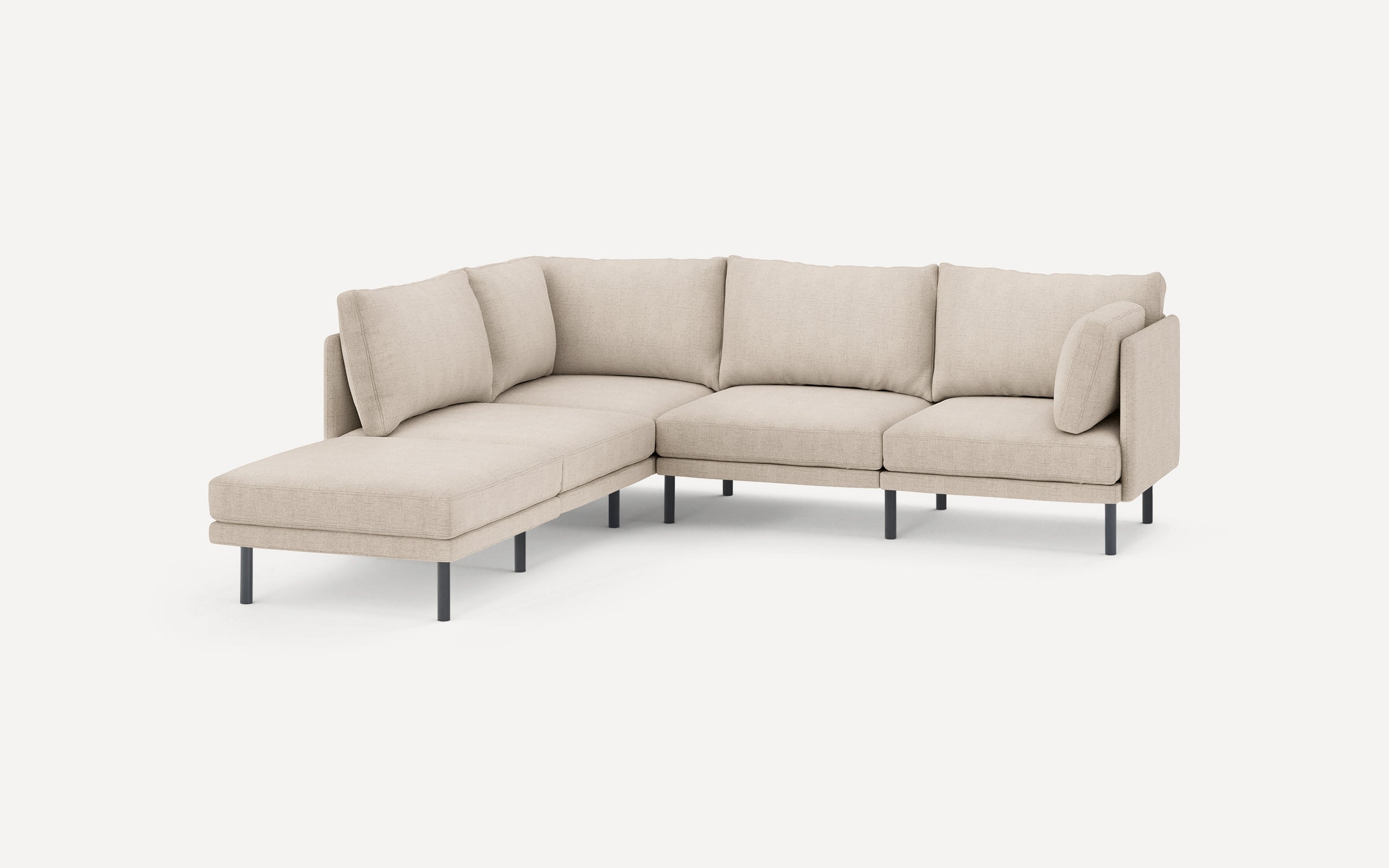 modern l - shaped sectional sofa with clean lines and soft beige fabric upholstery, featuring a chaise lounge, black metal legs, and