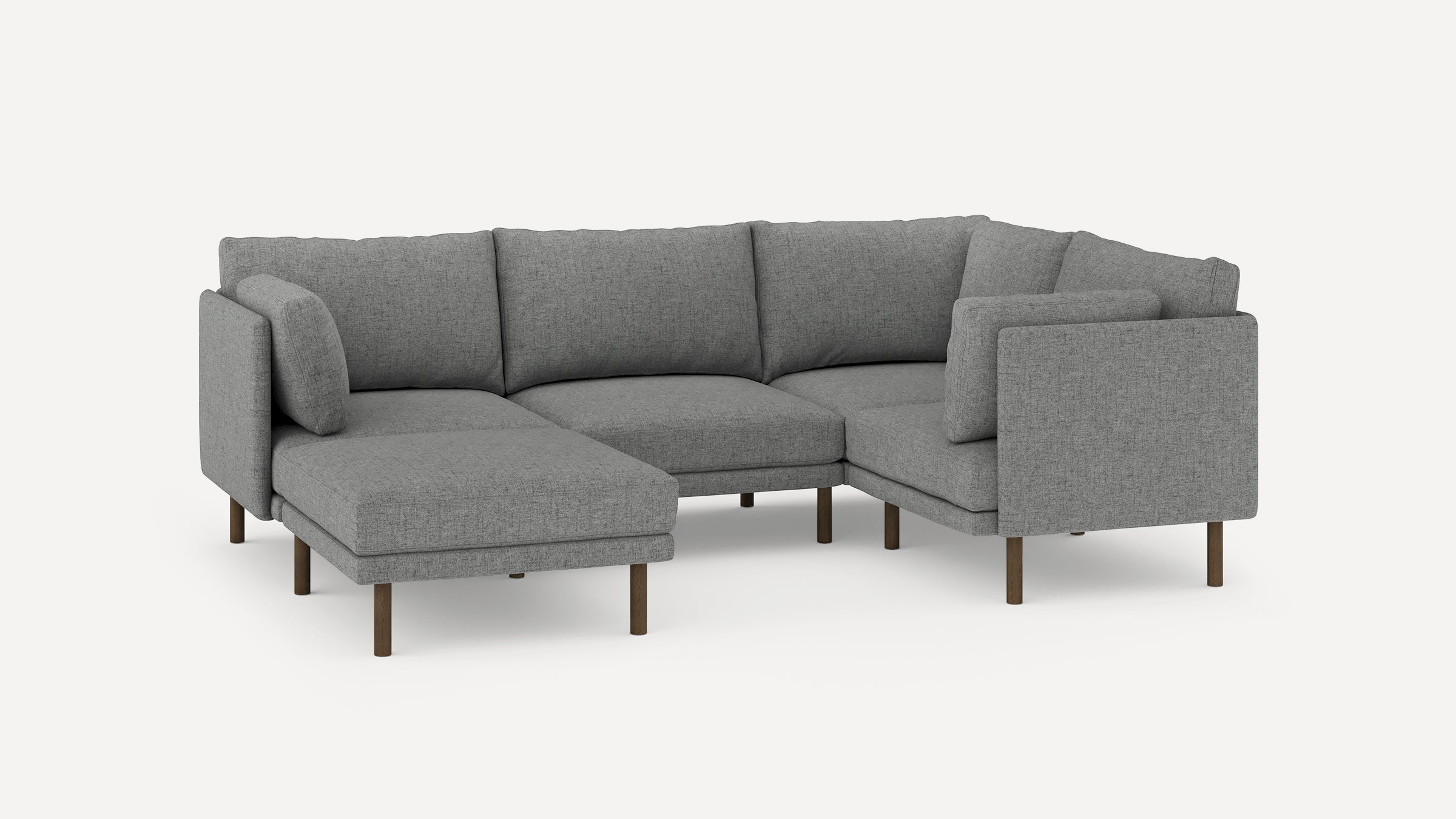 Modern L-shaped sectional sofa in gray fabric with wooden legs, featuring comfortable back cushions and a chaise lounge on the left side.