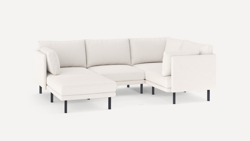 Modern white fabric sectional sofa with black metal legs, featuring a chaise lounge and plush cushions.