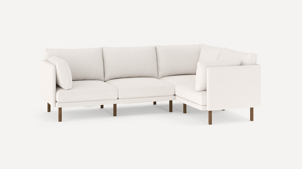 modern l - shaped sectional sofa with clean lines and wooden legs, featuring a soft white fabric upholstery, and a clean, minimal