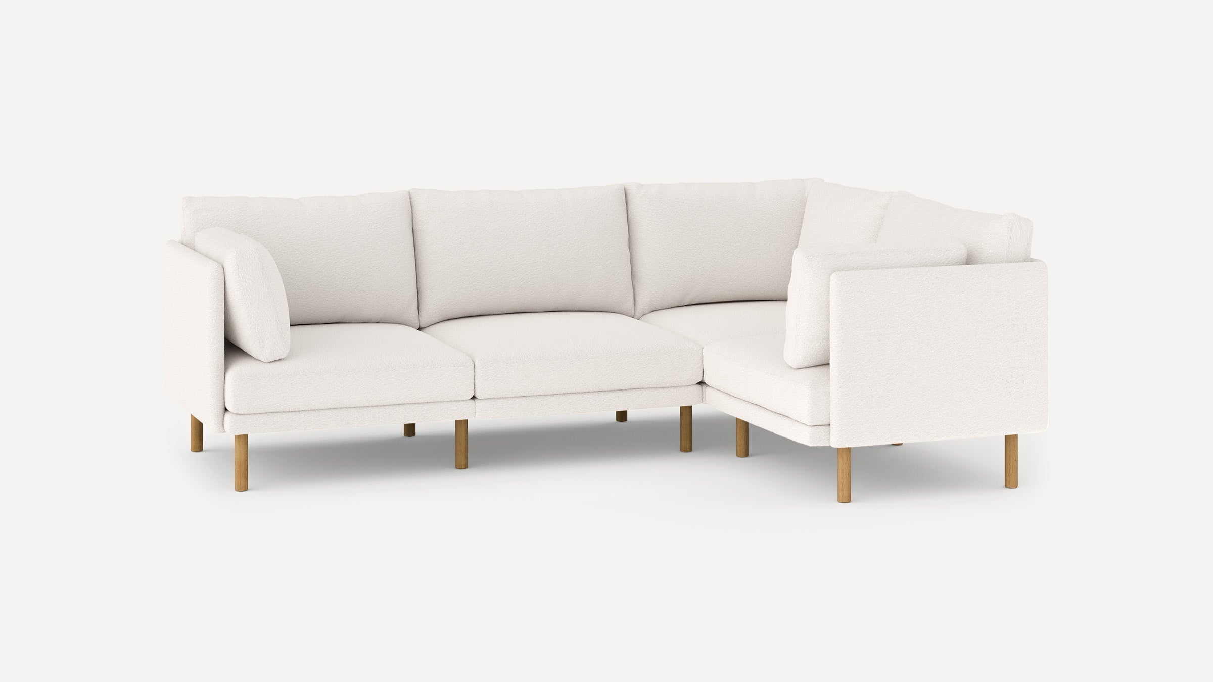 Modern white L-shaped sectional sofa with plush cushions and wooden legs, designed for comfort and style.
