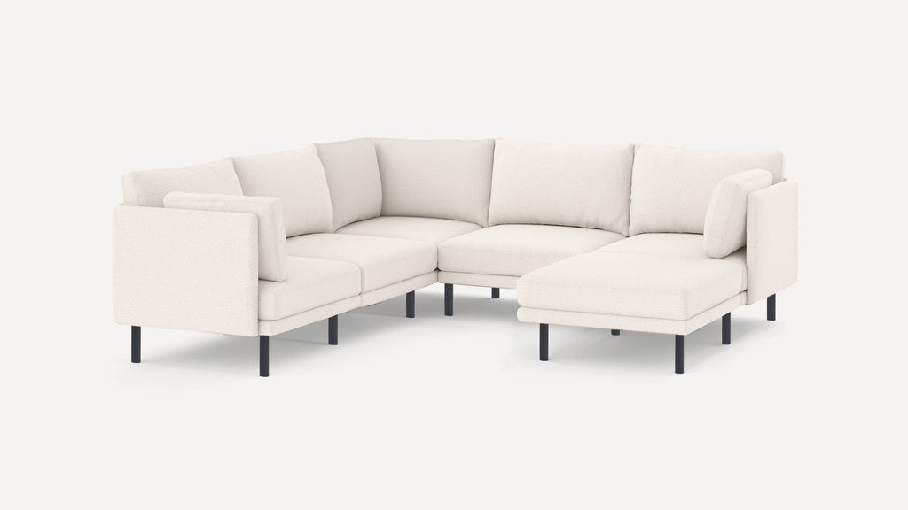 Modern white sectional sofa with plush cushions and black metal legs, featuring an L-shaped design and a chaise lounge on the right side.