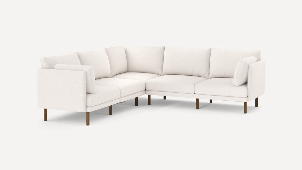 modern l - shaped sectional sofa with beige upholstery and wooden legs, featuring clean lines and clean lines on the back, on a