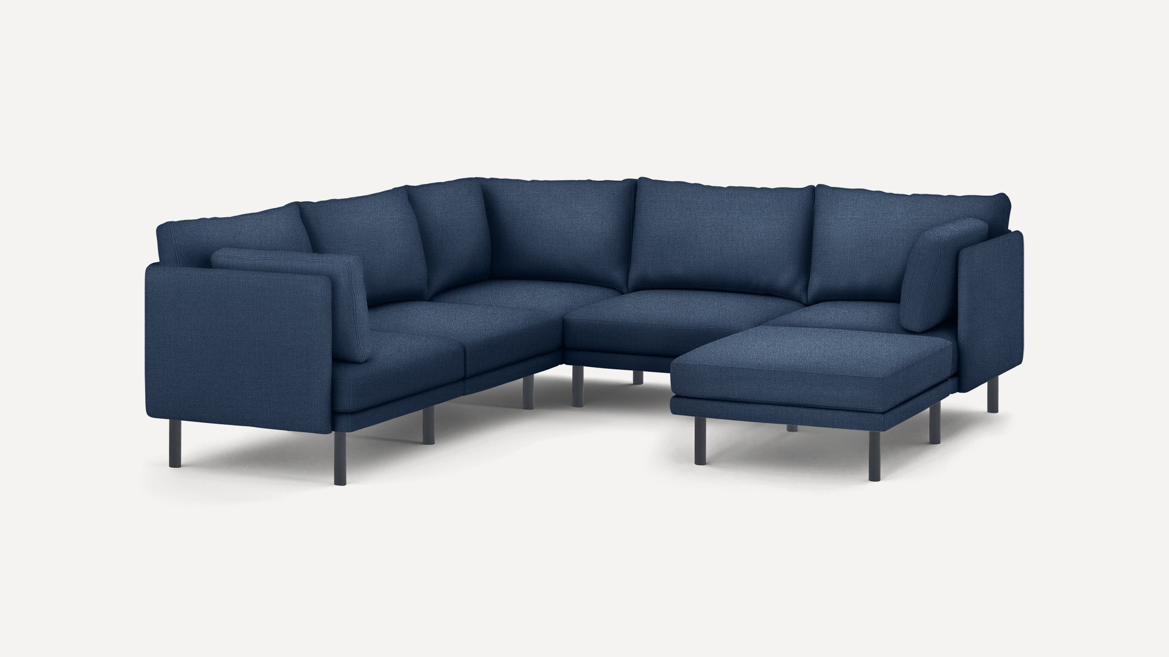 Modern navy blue L-shaped sectional sofa with plush cushions and slim black legs on a white background.