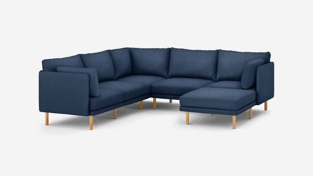 Modern navy blue sectional sofa with wooden legs, featuring a right-side chaise and plush back cushions.