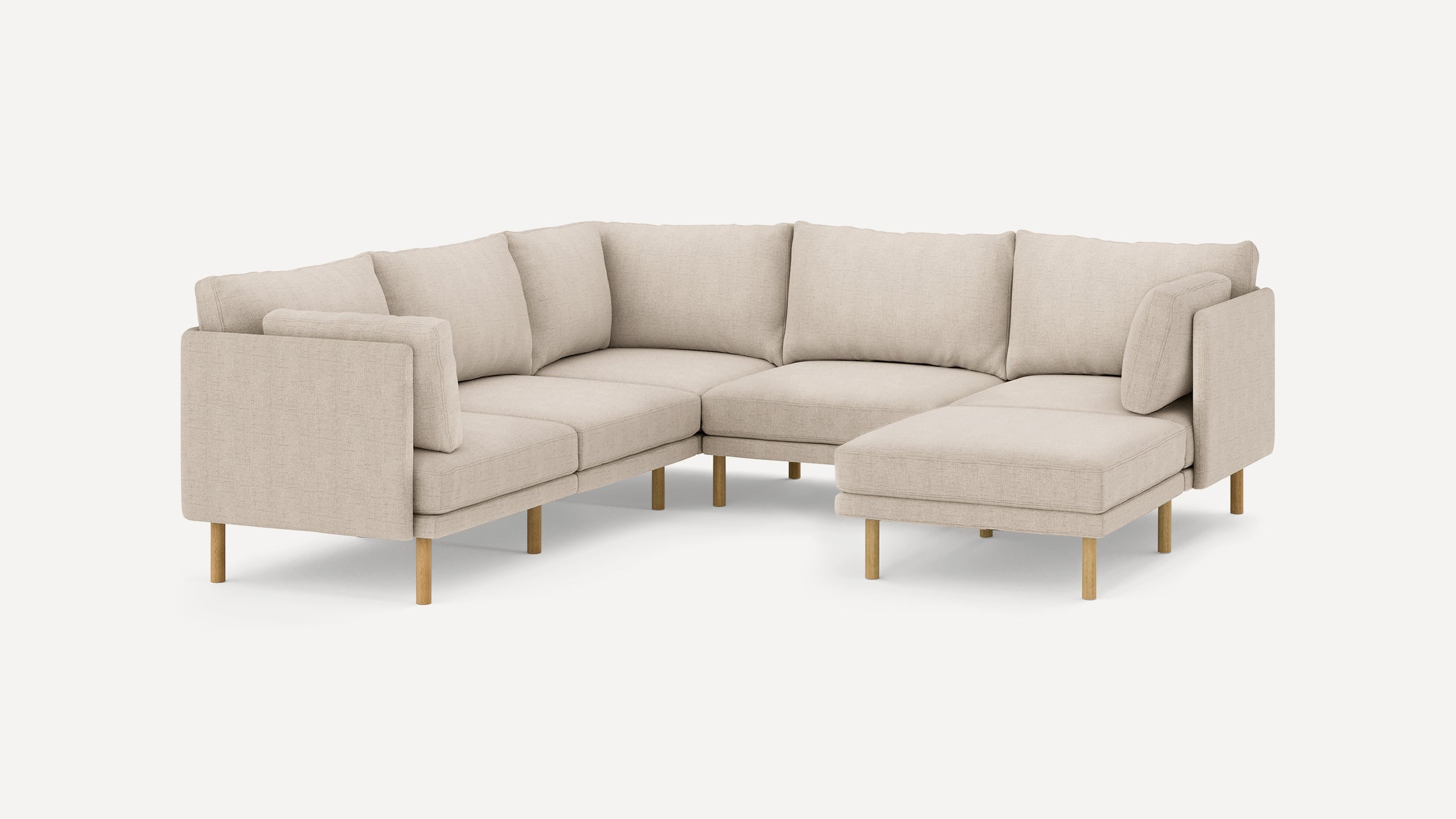 Beige L-shaped sectional sofa with wooden legs and eight cushioned backrests against a plain white background.